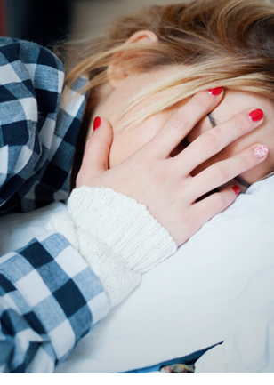 Young woman crying in bed after domestic violence at home
