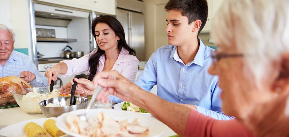Multi-Generation Family Sitting Around Table Eating thanksgiving Meal