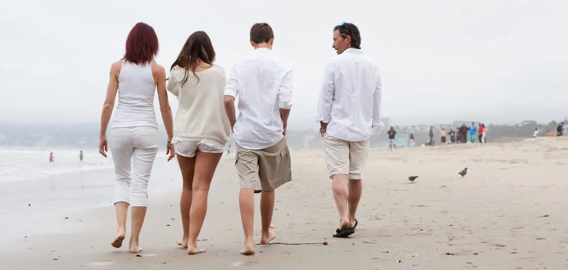 blended Family Walking Away On The Beach