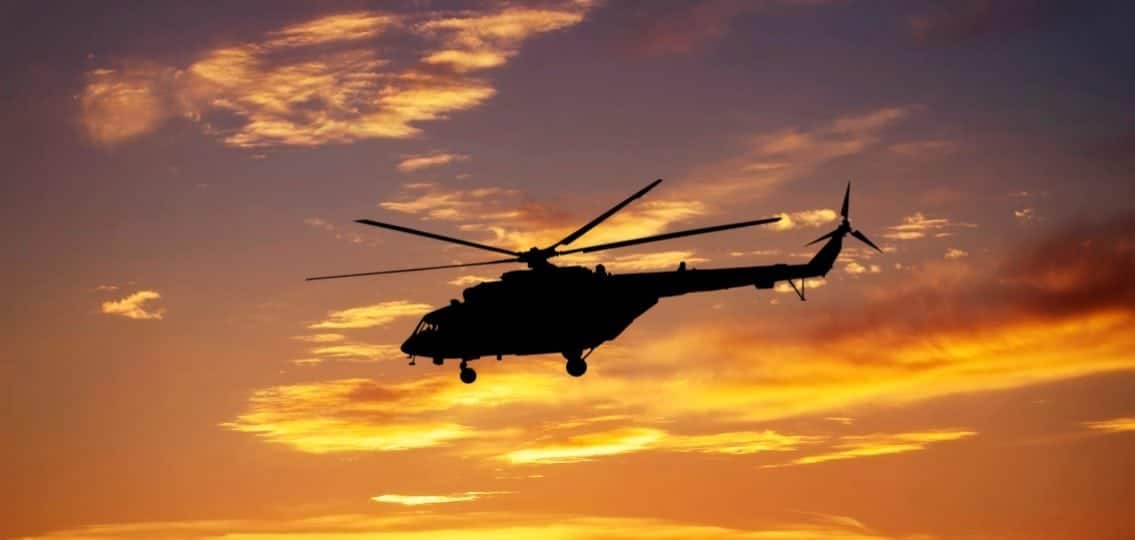 Picture of helicopter at sunset. Silhouette of helicopter on sunset sky.