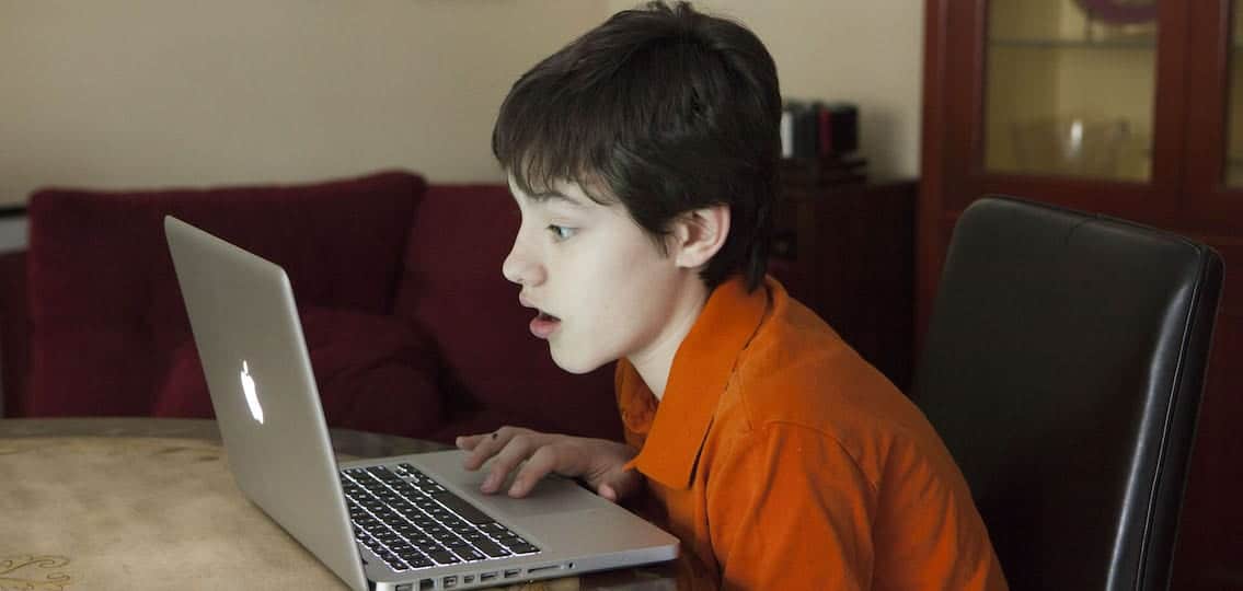 Shocked teenage boy on computer