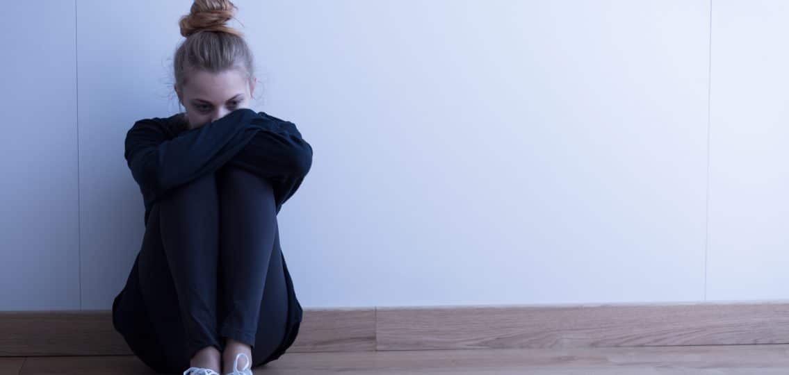 Sad woman with depression sitting on the floor