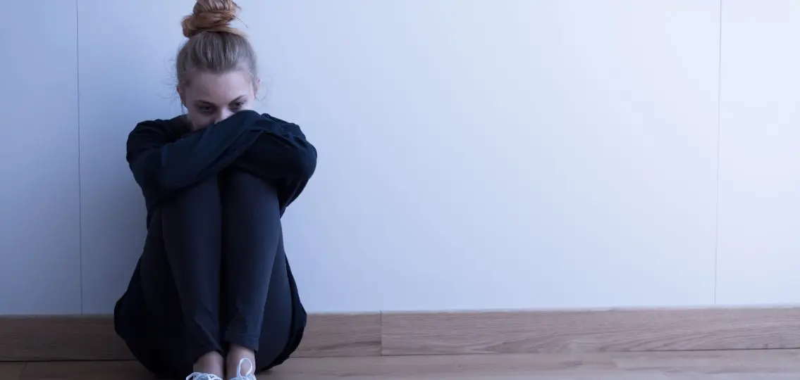 Sad woman with depression sitting on the floor