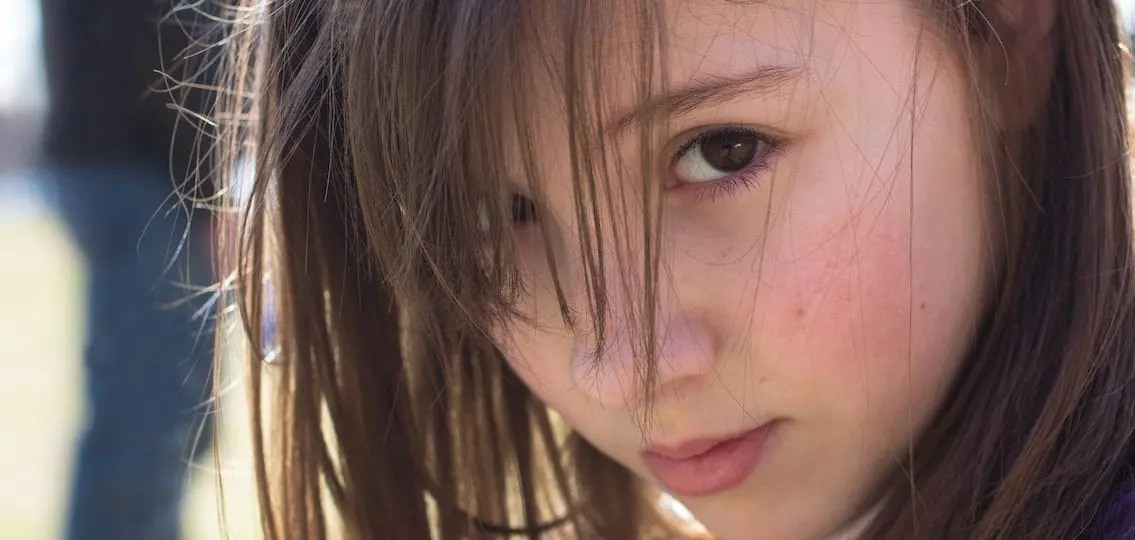 close up of a teen girl with her bangs in her face