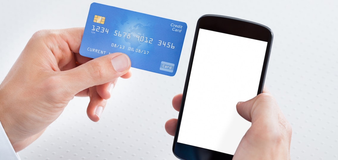 Man Holding Credit Card And Cell Phone Checking Account Balance