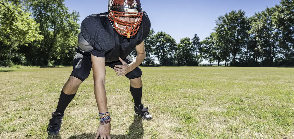 American football player offensive Lineman in in action at three point stance