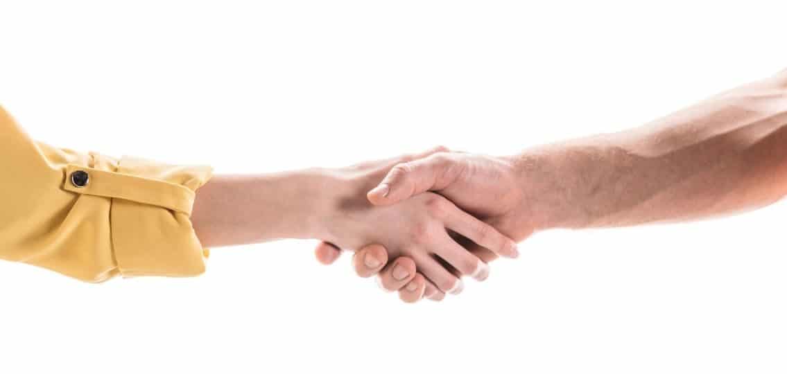 a man and woman shaking hands close up white background agreeing to keep things positive after divorce