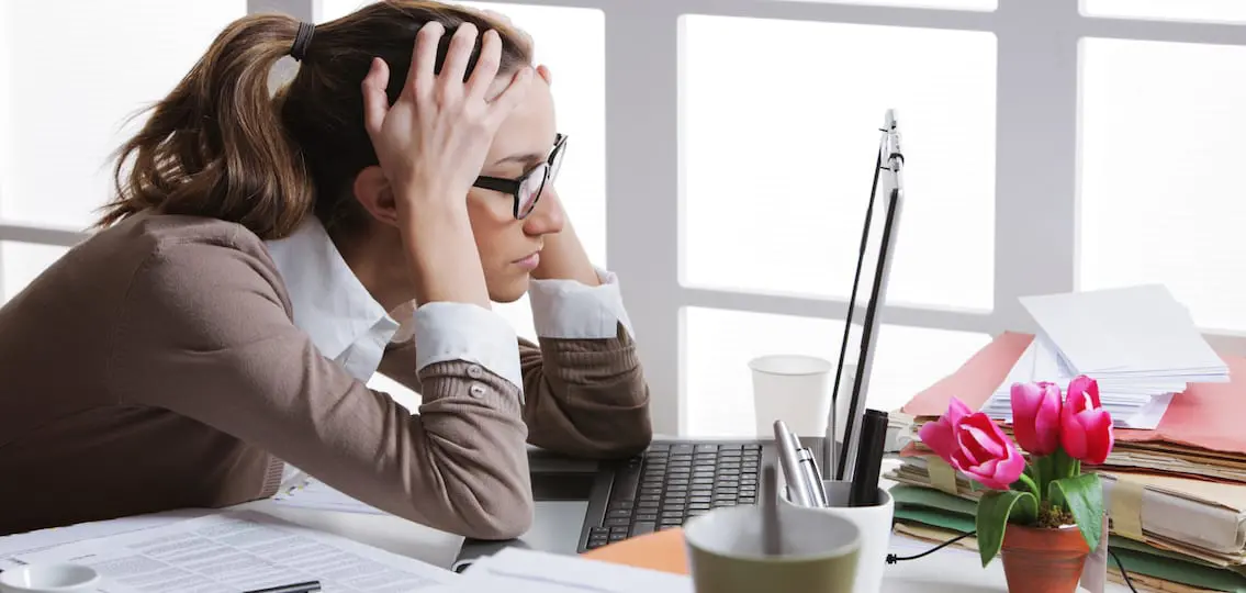 Young and beautiful businesswoman tired from work in the office. Woman holding her head