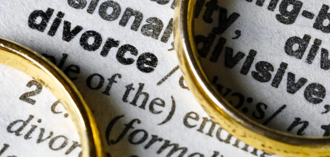 Two separate wedding rings next to the word divorce