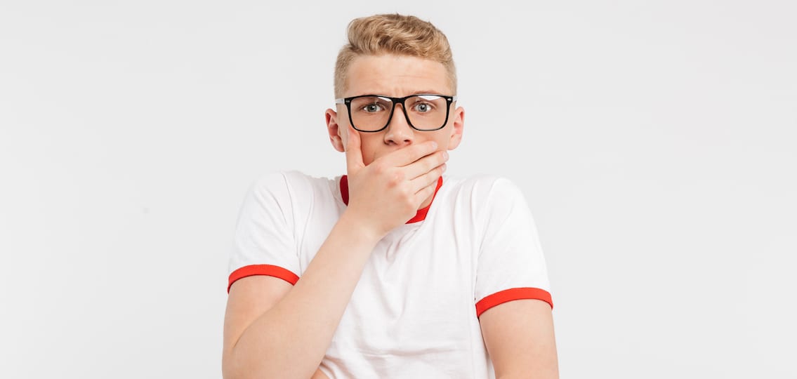 Portrait Of A Shocked Teenage Boy In Eyeglasses