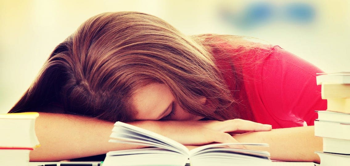 Sovande tonåring på ett skrivbord ingen sömn ritual