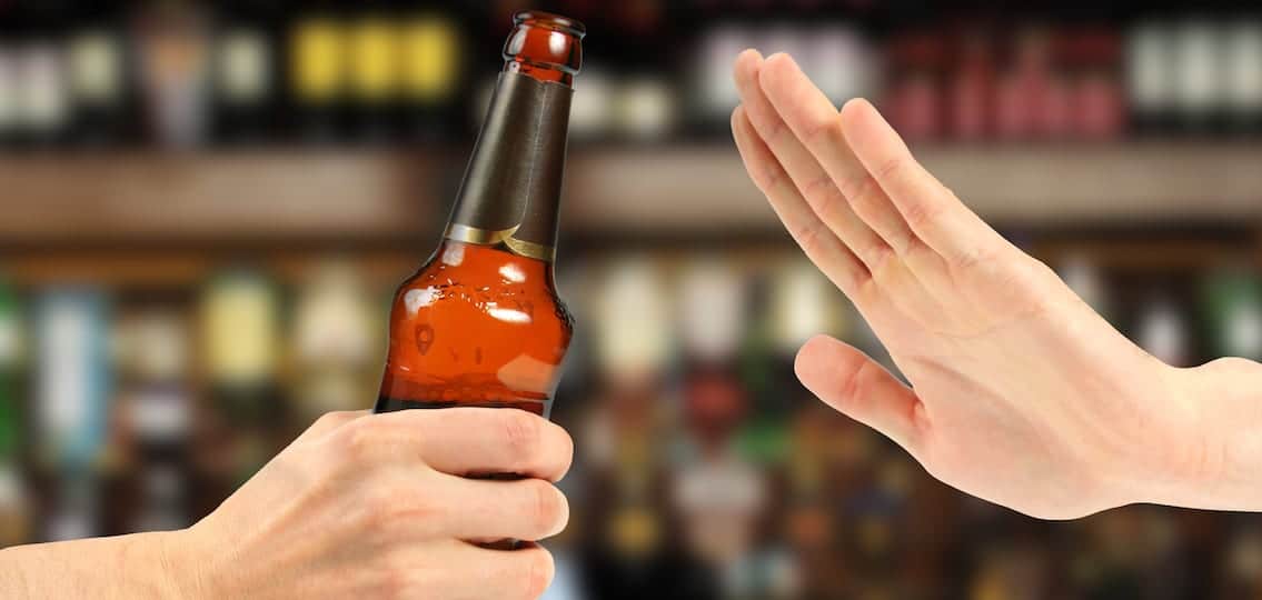 hand rejecting a bottle of beer in the bar