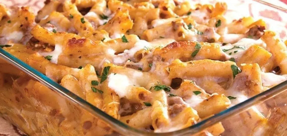 close up baked ziti with ground turkey in a glass baking dish