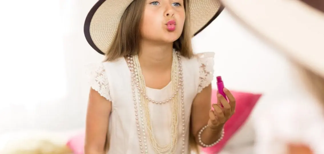 young girl playing dressup with her mom or sister's clothes and makeup