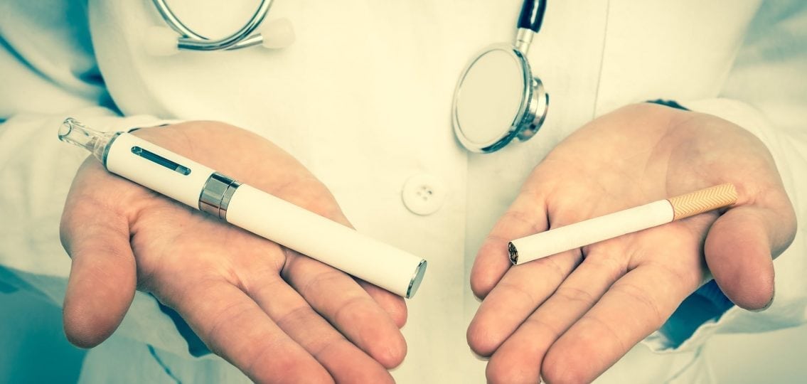 a doctor holding one cigarette and a vape in each hand