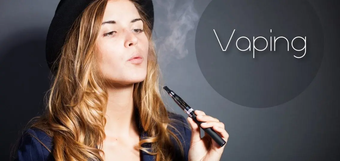 teen girl with a vape breathing out smoke with the caption Vaping