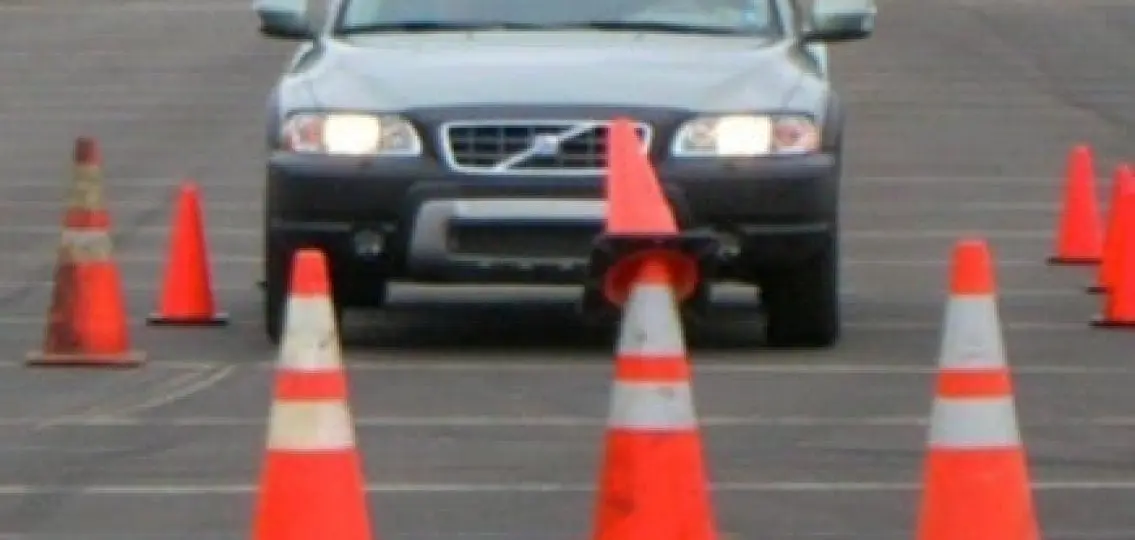 drivers ed car driving through orange cones running one over