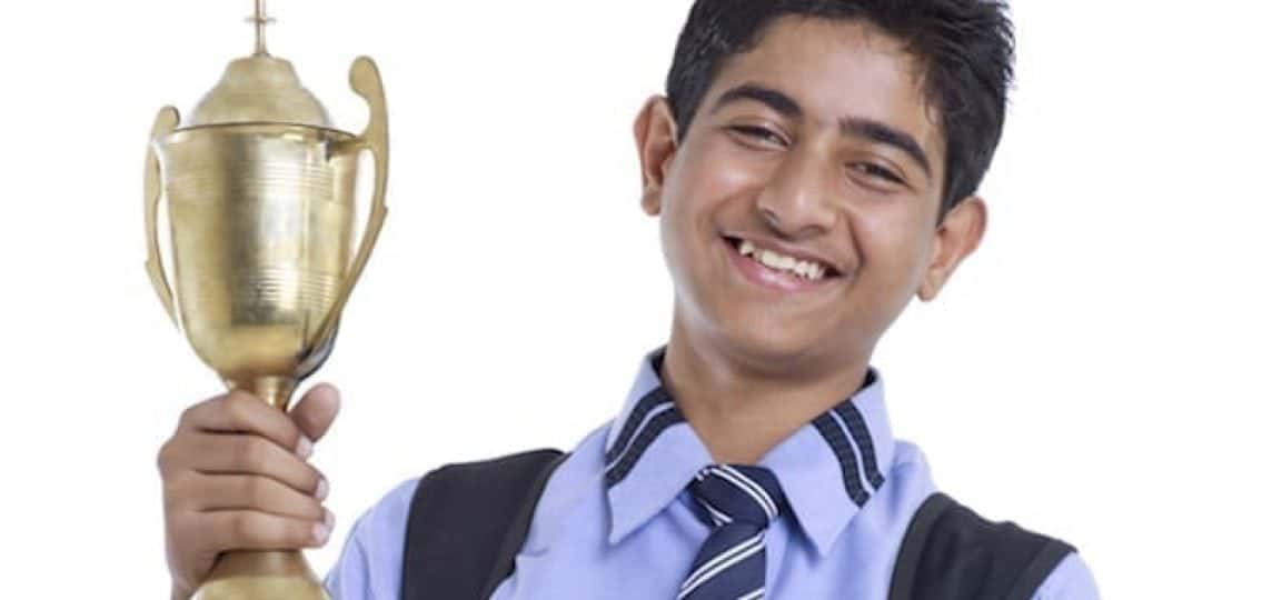 smiling boy holding a trophy