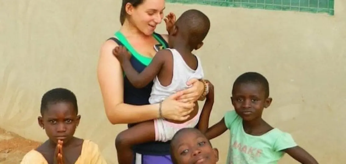 teenage girl caring for young children in Africa outdoors