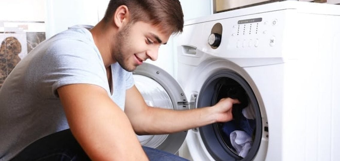 college student loading a laundry machine confidently