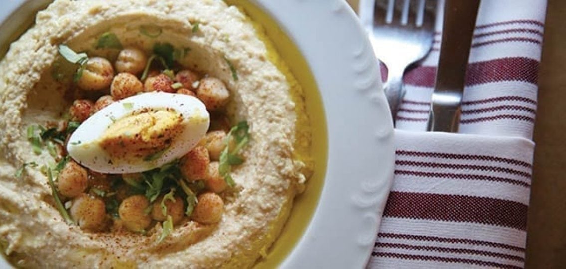 hummus on a plate with chickpeas and a hard boiled egg