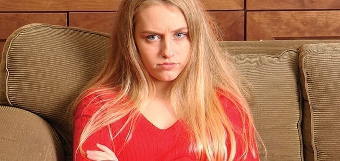 annoyed teen girl pouting on the couch
