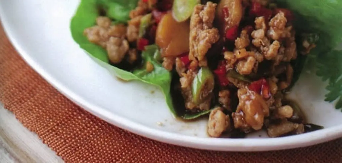 close up asian chicken lettuce wraps on a white plate