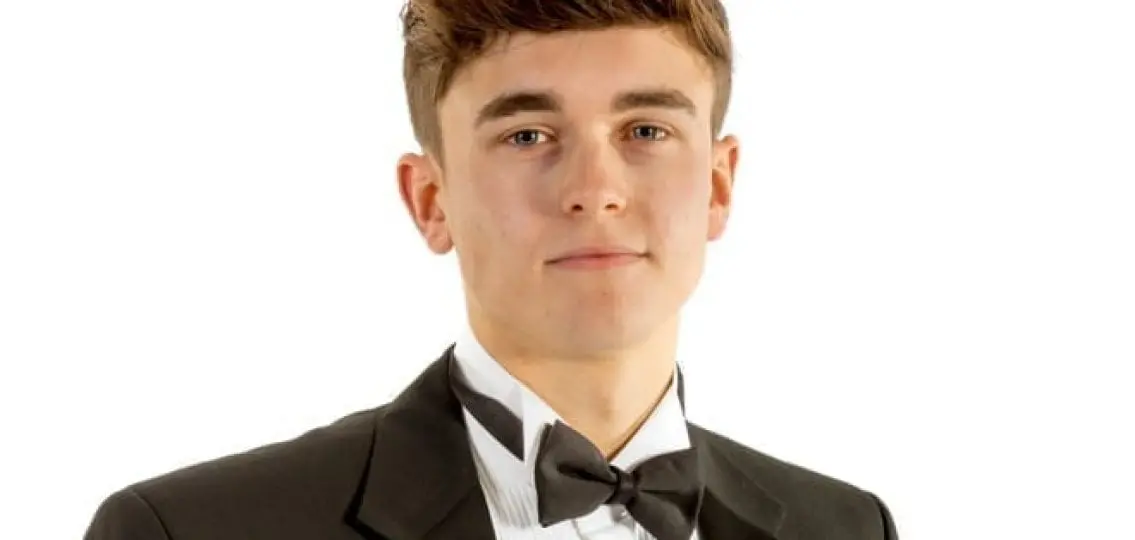teenage boy in a tuxedo white background