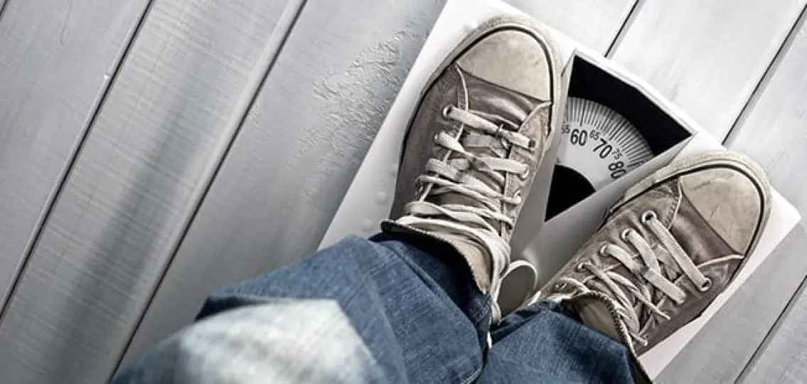 feet of an underweight teen boy standing on a scale reading 70 pounds