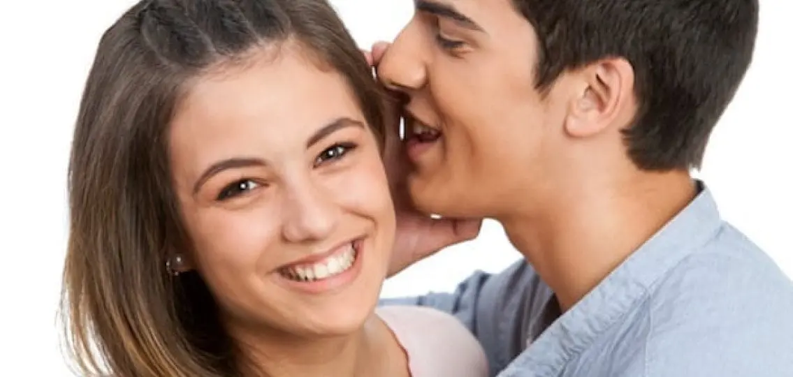 teen boyfriend and girlfriend boy whispering secret to girl