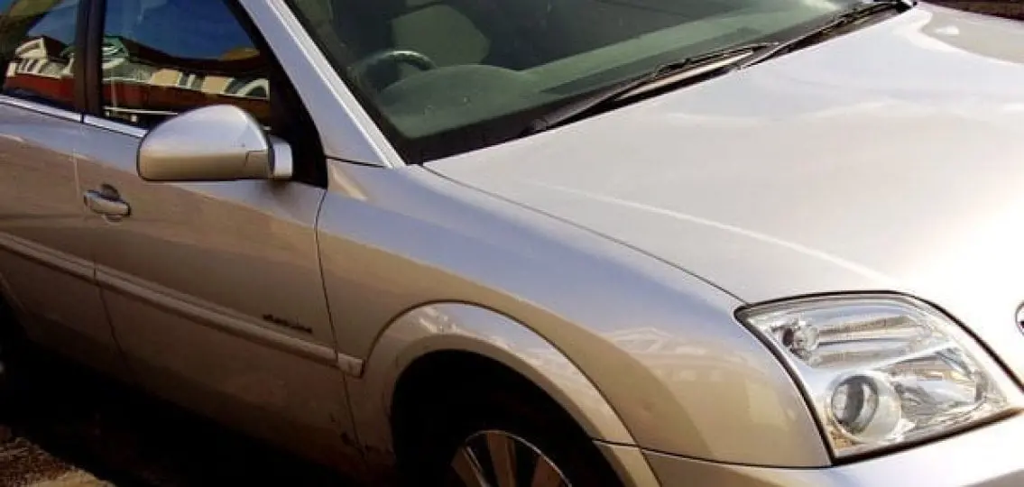 an empty beige car parked close up