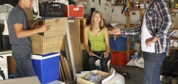 teens with their father doing chores cleaning the garage