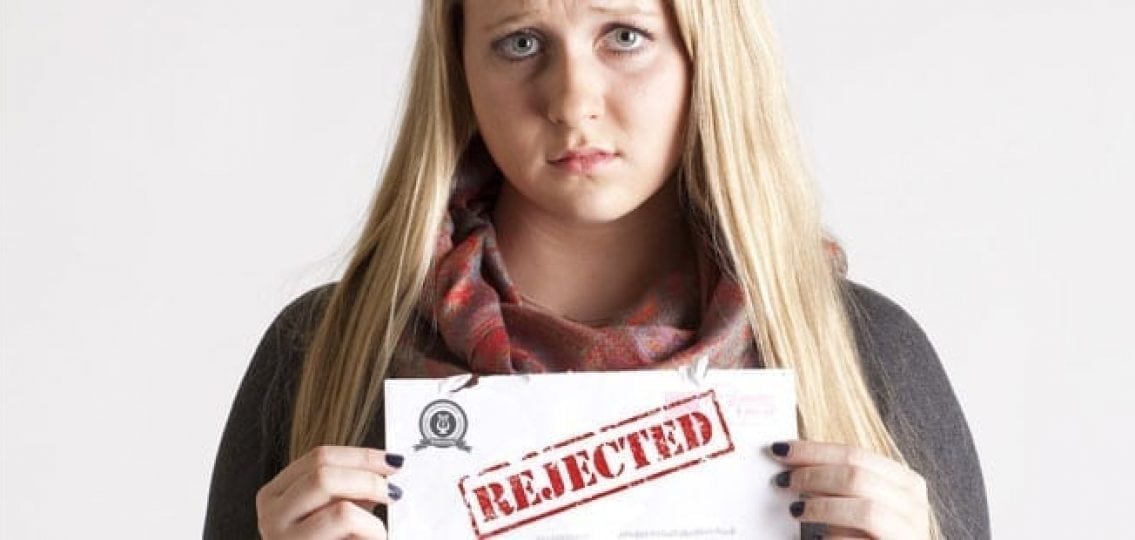 upset teen girl holding a college rejection letter