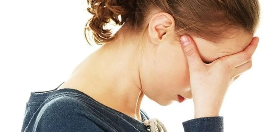 upset anxious teenage girl covering her face and looking away