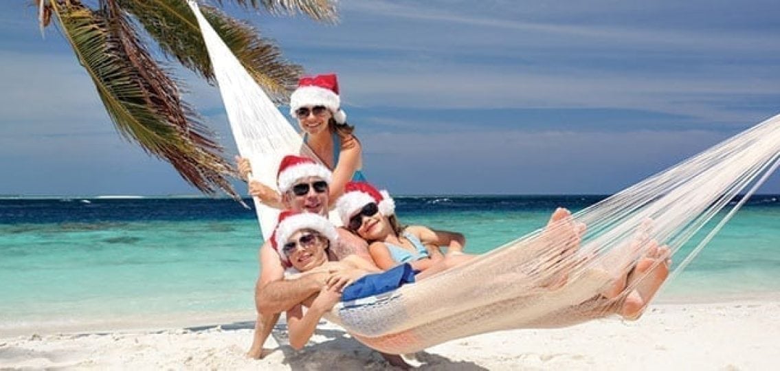 family on vacation on the beach wearing santa hats