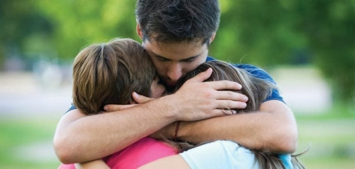 sad family dad hugging two teenagers