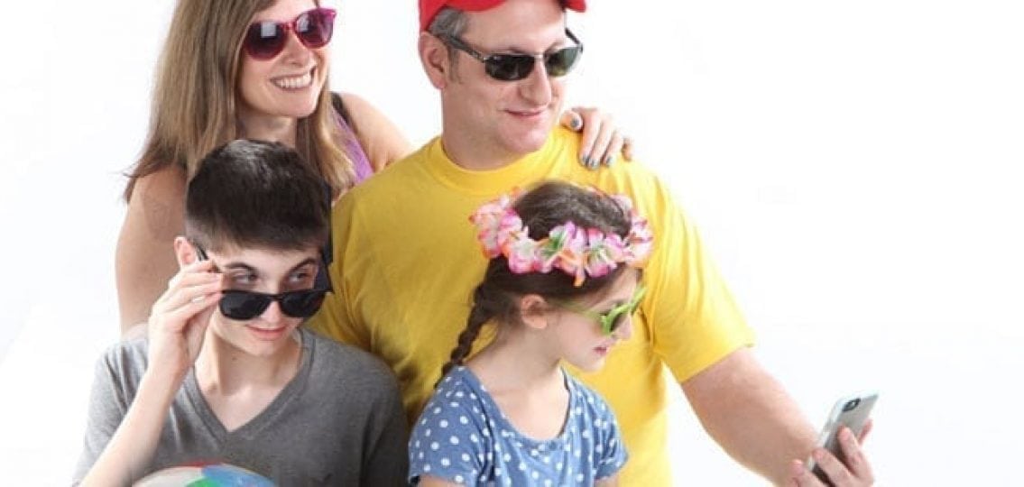 family vacation wearing sunglasses and looking at a cell phone