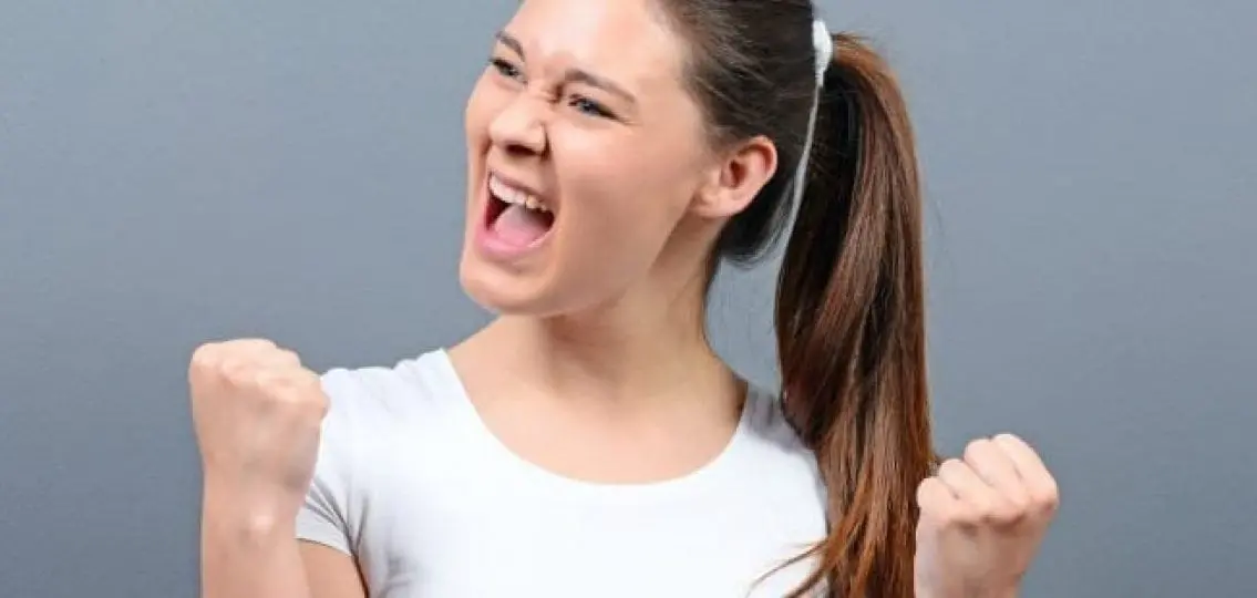 screaming excited teen girl on gray background