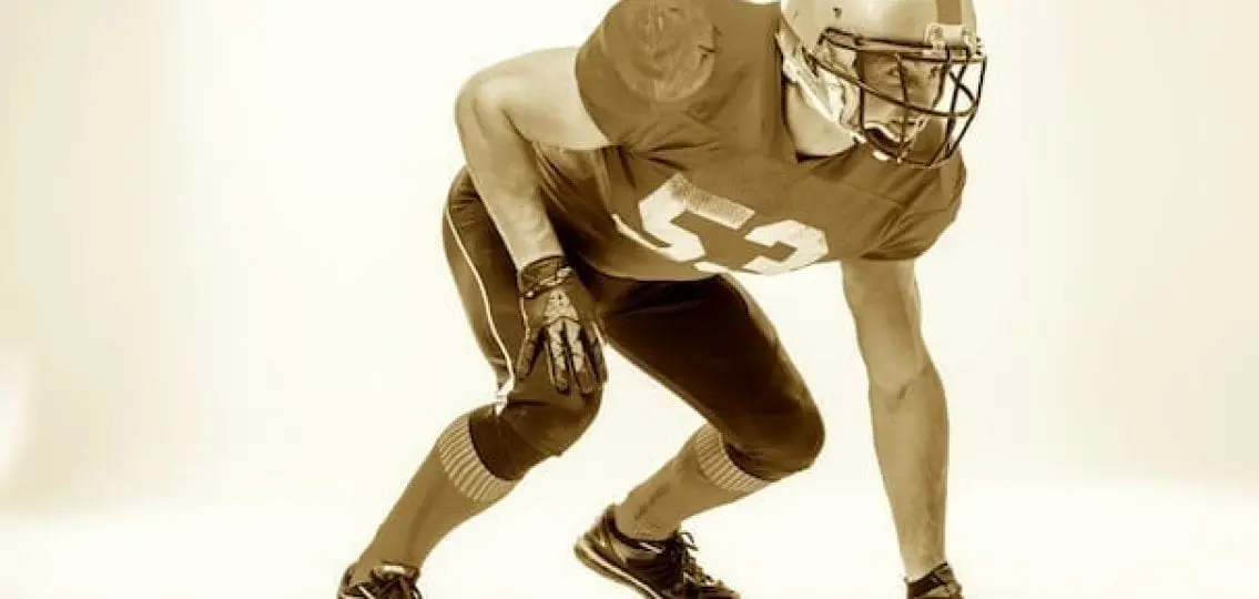 high school football player sepia tone on white background ready to begin play