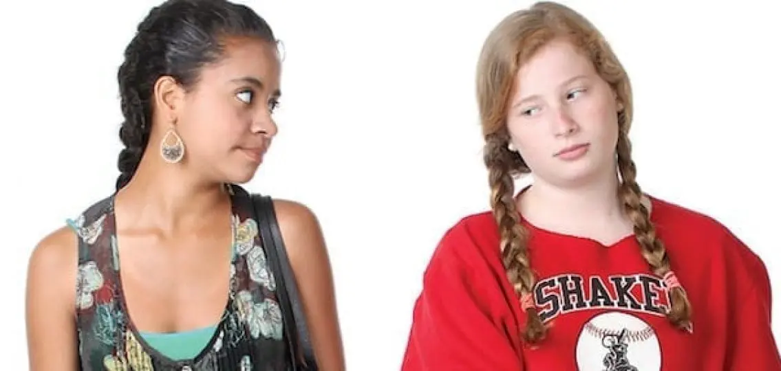 annoyed teen girls looking at each other