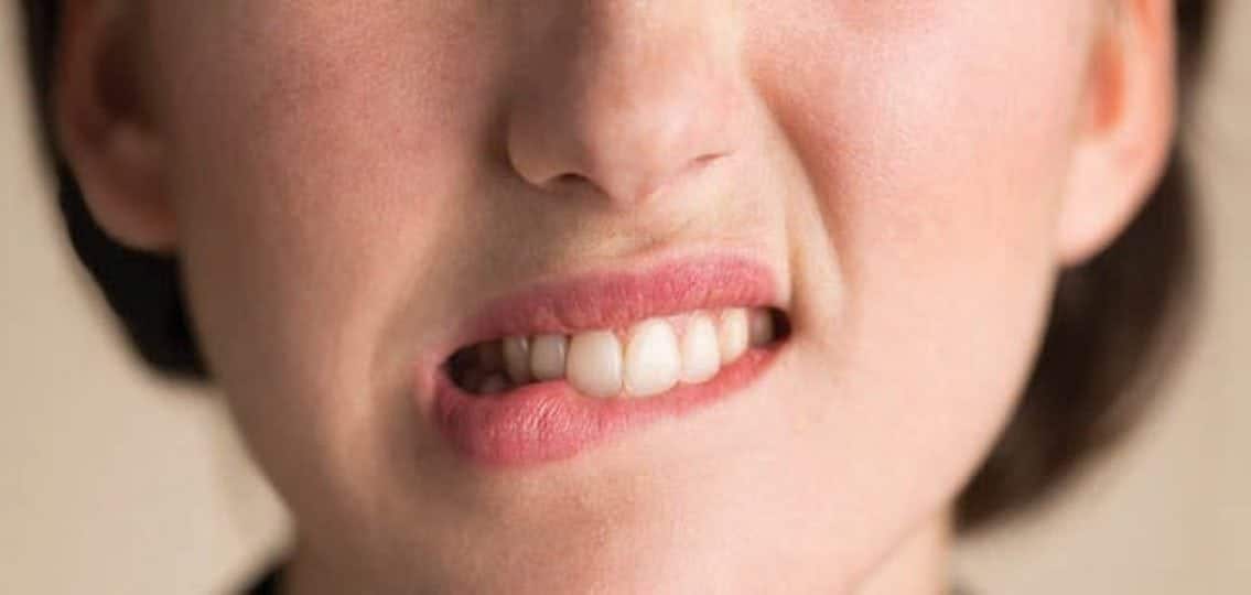 anxious teenage girl biting her own lip close up