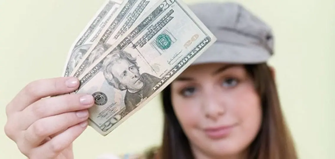 teen girl holding up cash money