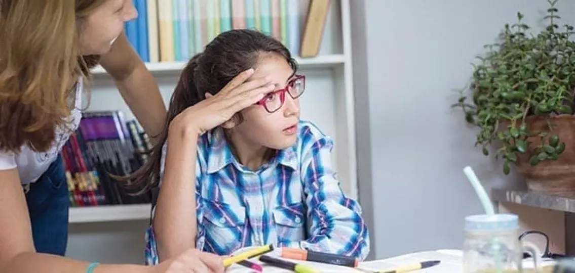 annoyed teenage girl ignoring her mom helping her with homework