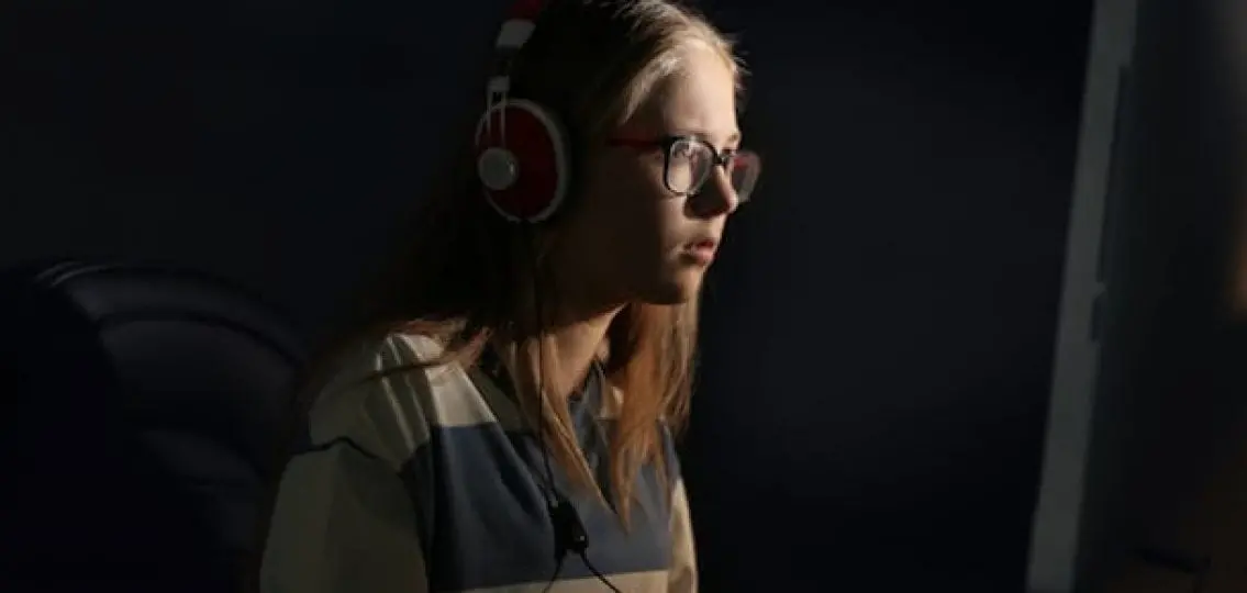 teenage girl on the computer in a dark room