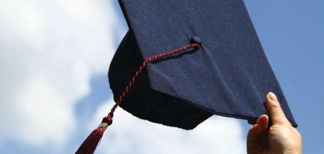 graduation cap being held in the air