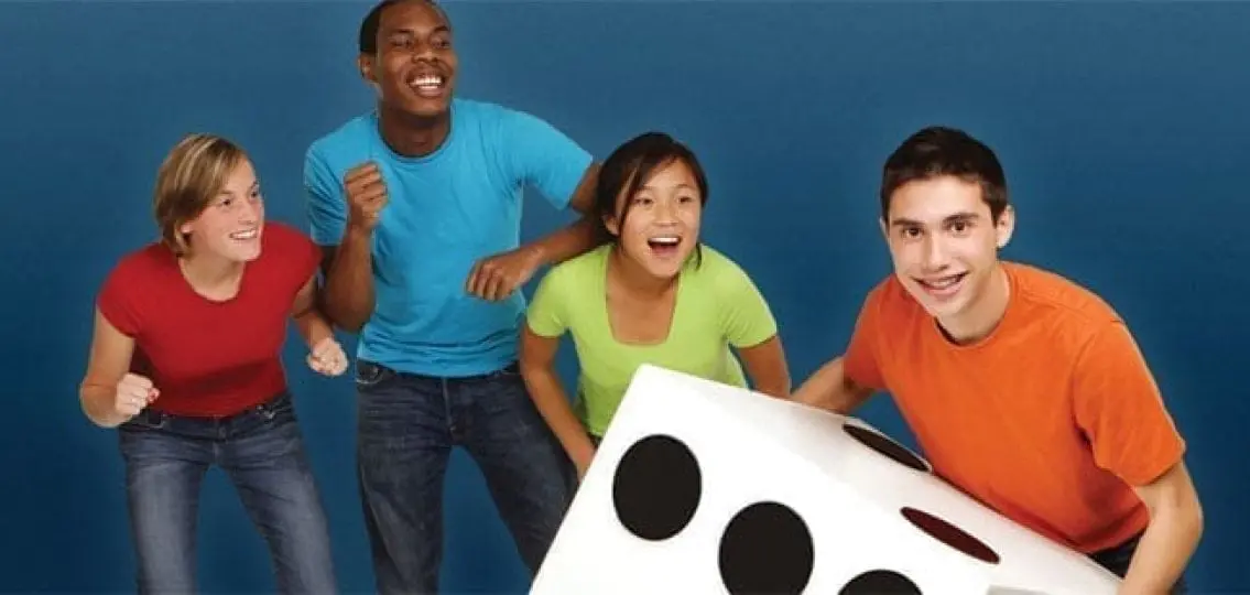 teenagers smiling and rolling a giant dice