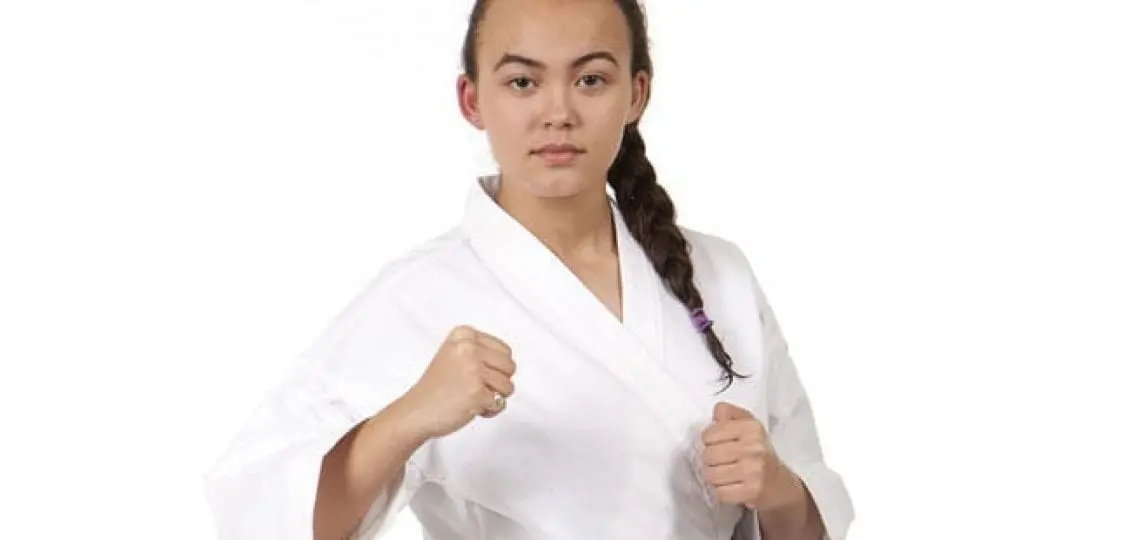 teenage girl in karate uniform fists up
