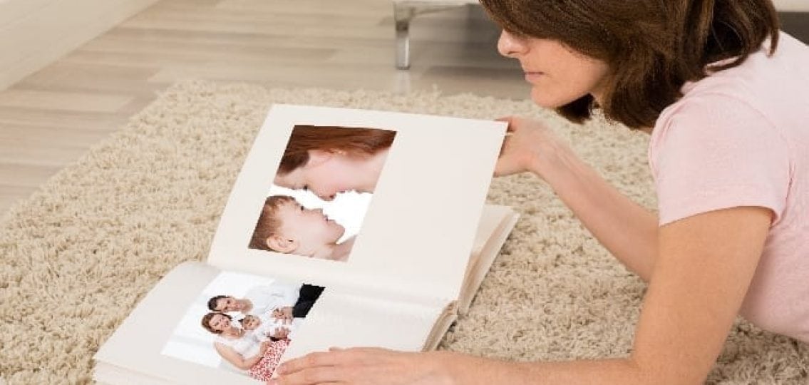 mom lying on carpet looking at a photo album