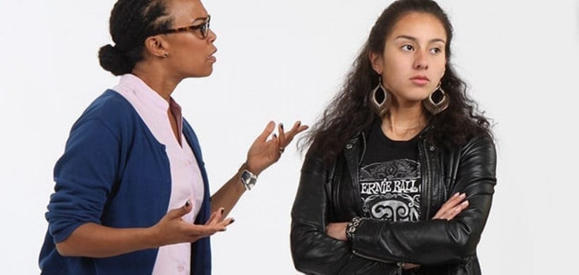 mom and daughter in an argument Daughter crossing arms in a leather jacket and ignoring as her mother lectures