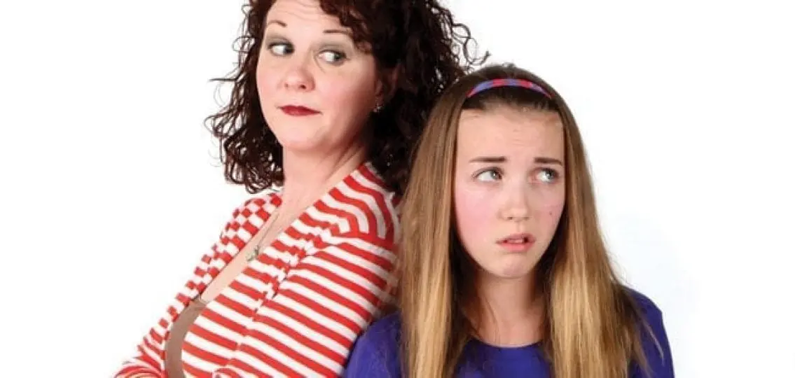 annoyed teen girl rolling her eyes as her mother scowls at her